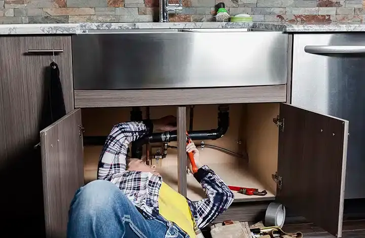 Tech repairing garbage disposal in Monroe Township, NJ.